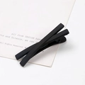 Minimalist matte black X-shaped hair clip with a smooth frosted finish on white card - Twisted Black