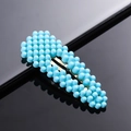 Close-up of an oval hair clip with dense blue pearlescent beads on a black surface - Blue Waterdrop