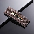 Detail shot of a brown matte finish pearl hair clip with metal BB grip on a sleek surface - Coffee Brown Rectangle