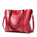 Detail of red vintage tote bag showing glossy leather texture and silver metal hardware - Red