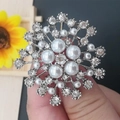 Sparkling silver snowflake brooch with white pearls and rhinestones shown in hand - No. 25-Silver Snowflake Pearl