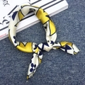 Square silk scarf with blue, yellow and white print patterns on dark textured surface - Flower