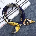 Foulard in seta blu navy e giallo con motivi geometrici su jeans scuri neri - Casa Calda