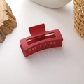 Close-up of a large matte wine red square hair claw clip on a minimalist background - Red