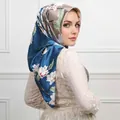 Floral satin hijab with blue and champagne patterns worn by a model in elegant style - #28 Peacock Blue Lily