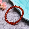 Detailansicht eines 7A Natur-Achat-Armbands auf einem blauen Porzellanteller - 6mm