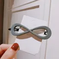 Gray infinity symbol hair clip in acrylic resin finish held on a display card - Large Infinity Shape / Gray Blue