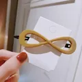 Fashionable ginger yellow infinity symbol hair clip on a white card display - Large Infinity Shape / Turmeric