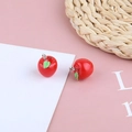 Close-up of red resin apple charms with green leaves and metal rings for DIY jewelry - Red Apple