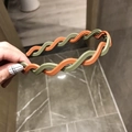 Close-up of twisted wavy headband in orange and green matte finish with small inner teeth - Green Orange