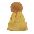 Detail of yellow knit baby hat featuring chunky cable stitch and fluffy faux fur pom-pom - Yellow