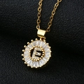 Macro view of gold flower pendant with cubic zirconia letter E on black leather - Gold Letter E