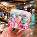 Colorful macaron hair ties for girls in a portable clear jar held by hand - 100 Pcs Jar / Spring Colors