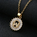 Macro shot of gold-plated W letter pendant with sparkling cubic zirconia on black texture - Gold Letter W