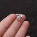 Dettaglio dell'orecchino a cerchio in argento con zirconi cubici tenuto sul dito - Stile Triangolo Radiante (11#)