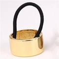Fashionable black ponytail holder with a polished gold alloy metal cuff on white background - Gold