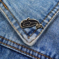 Detail of whale enamel pin with gold constellations on blue denim fabric jacket - Black Starry Whale
