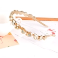 Close-up of golden headband featuring amber crystal rhinestones with a white mug background - Teardrop Gold Rhinestone