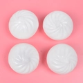 Set of four white steamed bun shaped squeeze stress balls on a pink background - Steamed Bun Squeeze Toy