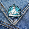 Detailed view of shark enamel pin with 'Shark Week' slogan on blue denim jacket - Slogan Shark