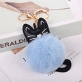 Dettaglio di un pompon in ecopelliccia celeste e ciondolo a gatto in PU nero su portachiavi - Celeste