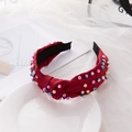 Red knotted pearl headband with colorful beads on white fabric and lace background - Burgundy