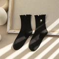 Black mid-calf socks for women featuring ruffled edges and small daisy embroidery - One Size / Black