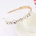 Elegant gold metal headband with clear rhinestones resting on a white ceramic cup - Style 11-Gold