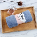 Detail of rolled soft blue coral fleece towel with pink sleeve on a wooden tray - 35*75cm / Dark Blue