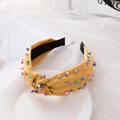 Yellow knotted fabric headband with colorful beads on a white tray display - Bright Yellow