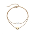 Detail of a double-layer gold anklet featuring a white pearl and a gold heart pendant - Layered Pearl Heart Gold Set