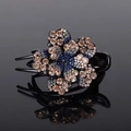 Flower rhinestone hair clip featuring champagne and blue crystals on black base - Champagne Grey