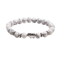 Detail of white turquoise beaded bracelet with silver elephant accent on white background - Elephant