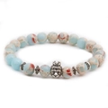 Macro detail of elastic bead bracelet featuring Imperial Jasper and a crowned lion charm - Crown Animal
