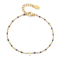 Detailed view of a gold stainless steel bracelet with blue beads and a cross pendant - Sapphire Blue