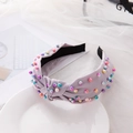 Pale purple knotted headband with colorful faux pearls on a white display plate - Light Purple