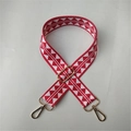 Dettaglio della tracolla tessuta con motivo etnico rosso e bianco e ganci in metallo oro - Rosso