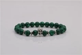 Green malachite beaded bracelet with silver skull charm on a reflective background - Skull Accessory