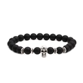 Macro shot of matte black beaded bracelet featuring a detailed silver skull accent - Skull