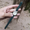 Close-up of cat-eared silver watch case with dark green leather strap on wrist - Green (63691)