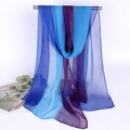 Dettaglio della sciarpa in georgette trasparente con sfumature blu e viola su barra metallica - Blu viola