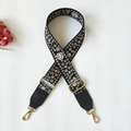Detail view of floral embroidered black bag strap with gold metal hooks and leather ends - Silver Clasp / Black Small Floral + Black Leather