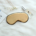 Golden silk sleep mask with black piping trim on a soft white plush background - Adjustable Buckle Paper Card Packaging / Gold