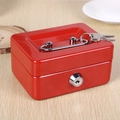 Detailed view of red metal cash box with silver handle and keys on a wooden desk - Red