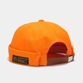 Dettaglio del berretto docker arancione con cinturino in pelle ed etichetta tessuta - Regolabile / Arancione brillante
