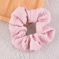 Dettaglio della trama a bolle e delle pieghe in tessuto rosa dell'elastico per capelli - Rosa