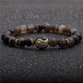 Macro shot of 8mm agate beads bracelet featuring a gold-studded Yin Yang charm centerpiece - Brown
