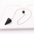 Macro shot of black crystal pendulum pendant with silver chain on white ceramic tray - Conical Stone + Silver Chain / Black Agate