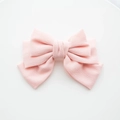 Detalle de una pinza para el cabello con lazo rosa multicapa en tela con textura - Rosa