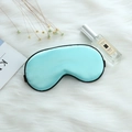 Mint blue faux silk sleep mask with black trim and adjustable strap on plush fabric - Adjustable Buckle Paper Card Packaging / Fresh Green